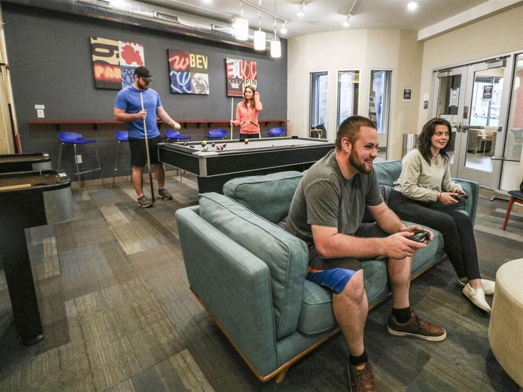a group of people playing video games in a living room at Bluestone Lofts, Minnesota, 55803