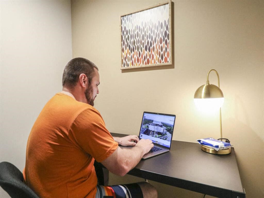 a man sitting at a desk using a laptop computer at Bluestone Lofts, Duluth Minnesota