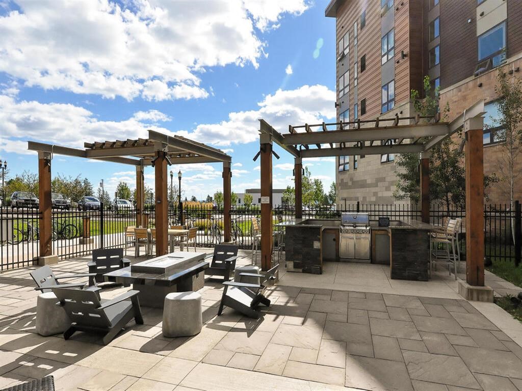 an outdoor patio with picnic tables and a grill at Bluestone Lofts, Duluth, MN