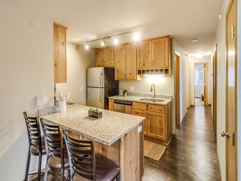 a kitchen with a marble counter top and wooden cabinets