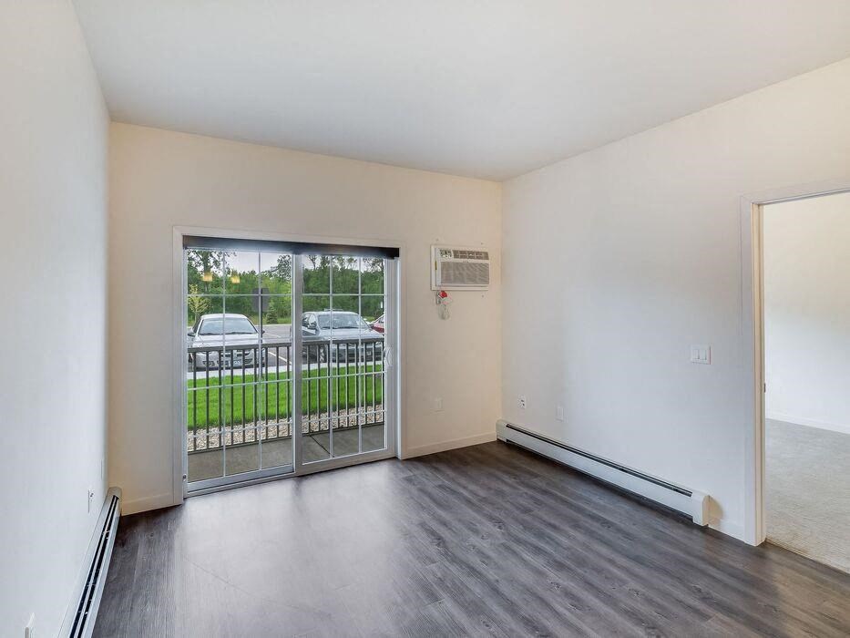 an empty living room with a door to a balcony at Arbor Ridge, Forest Lake, MN