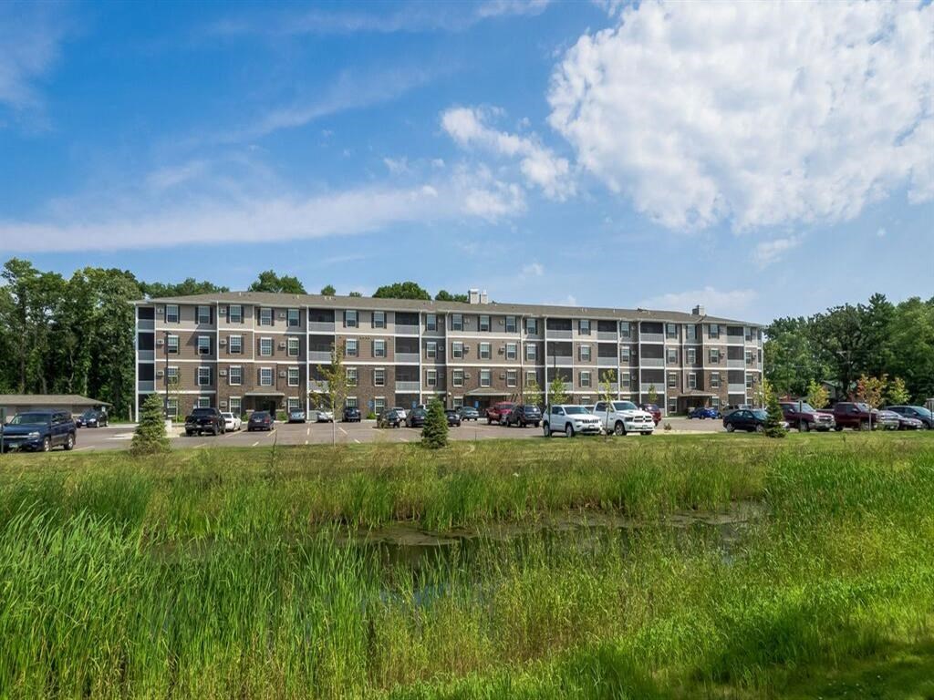 a large apartment building with cars parked in front of it at Arbor Ridge, Forest Lake, MN, 55025