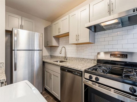 a kitchen with stainless steel appliances and white cabinets