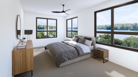 A bedroom with a large bed and a view of the lake.