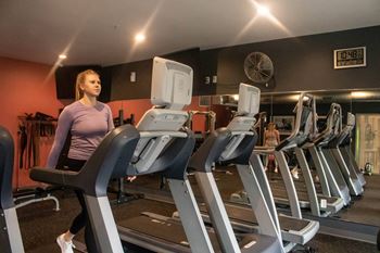 a woman running on a treadmill at a gym at Bluestone Lofts, Minnesota