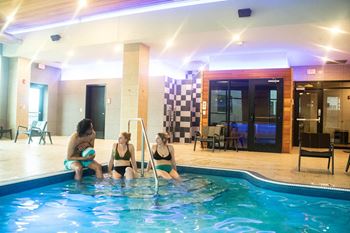 three women sitting in a swimming pool at a hotel at Bluestone Lofts, Duluth, 55803