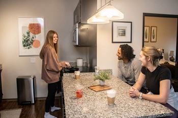 two women and a man sitting at a kitchen counter at Bluestone Lofts, Duluth, MN 55803