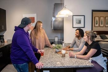 a group of people gathered around a kitchen table at Bluestone Lofts, Minnesota, 55803