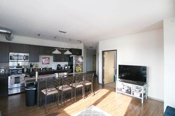 a kitchen and living room with a bar and a television at Bluestone Lofts, Duluth Minnesota