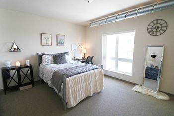 a bedroom with a bed and a large window at Bluestone Lofts, Duluth Minnesota