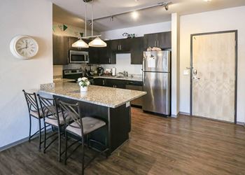 a kitchen with a marble counter top and a stainless steel refrigerator at Bluestone Lofts, Duluth, 55803