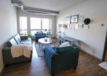 a living room with couches and a table at Bluestone Lofts, Minnesota, 55803