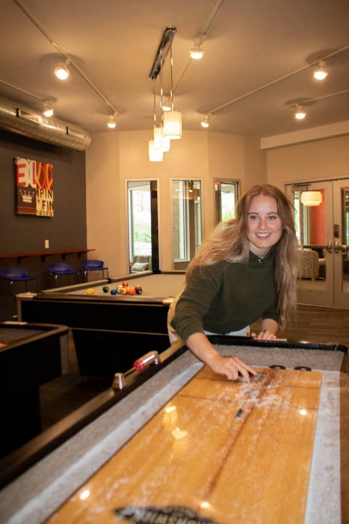 a young woman standing at a pool table at Bluestone Lofts, Duluth, MN, 55803