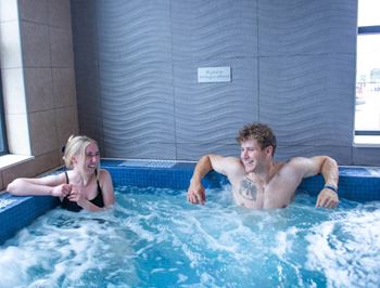 a man and a woman in an indoor swimming pool at Bluestone Lofts, Duluth, MN 55803