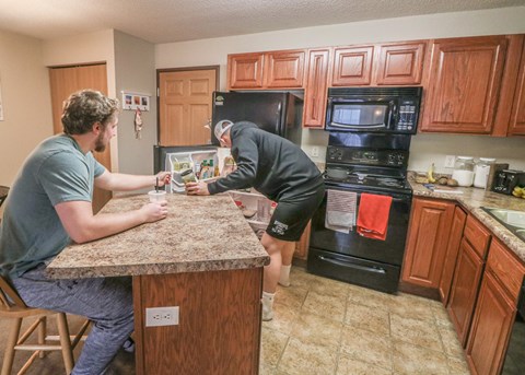 two men working on the counter in a kitchen