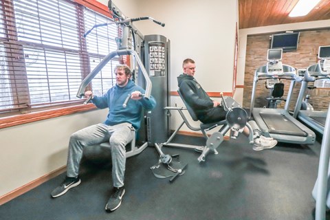 two men and a dog sitting on the gym equipment at Summit Ridge, Duluth, MN, 55811