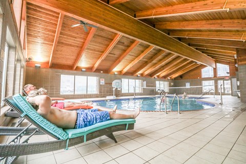 a couple of people are laying in a swimming pool at Summit Ridge, Duluth