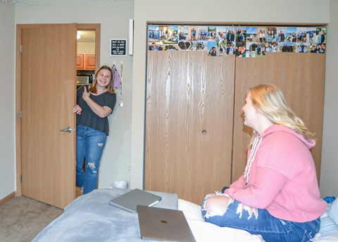 two women sitting on a bed in a room with a laptop at Summit Ridge, Duluth, Minnesota