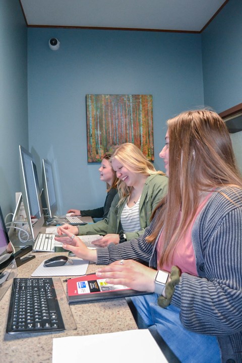 three women sitting at a desk working on computers at Summit Ridge, Duluth, MN, 55811