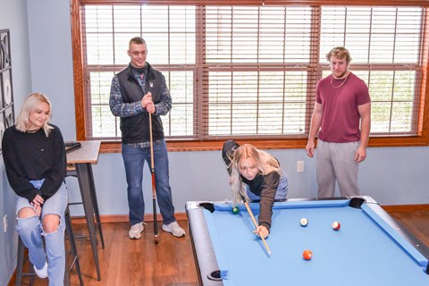 a group of people standing around a pool table at Summit Ridge, Duluth, MN, 55811