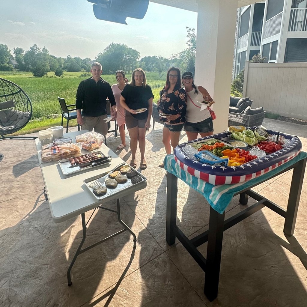 a group of people standing around a table with food on it  at Timber Ridge, Forest Lake, MN, 55025