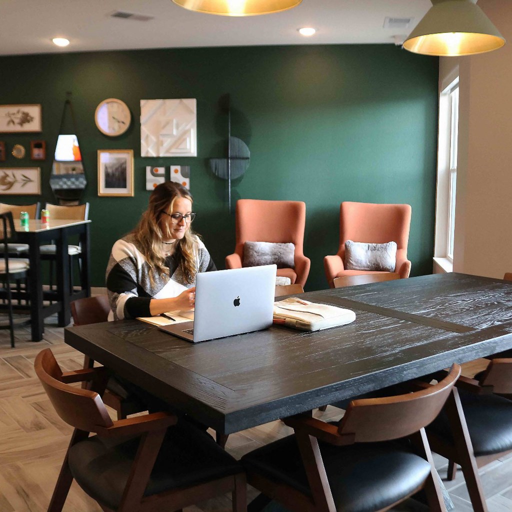 a woman sitting at a table with a laptop computer  at Timber Ridge, Forest Lake, 55025
