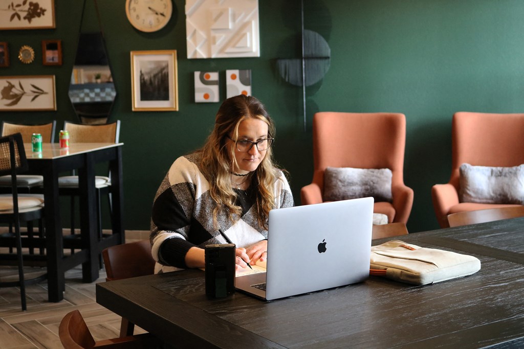 a woman sitting at a table using a laptop computer  at Timber Ridge, Forest Lake