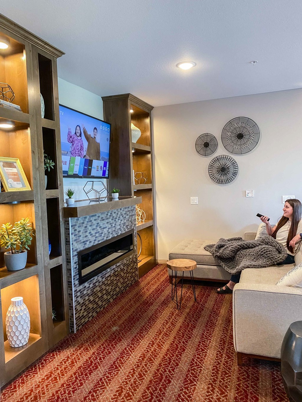 a woman sitting on a couch watching tv in a living room  at Timber Ridge, Minnesota