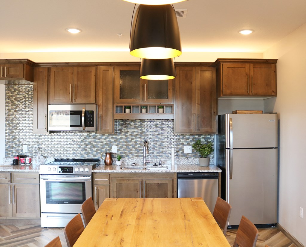 a kitchen with stainless steel appliances and a wooden table  at Timber Ridge, Minnesota, 55025