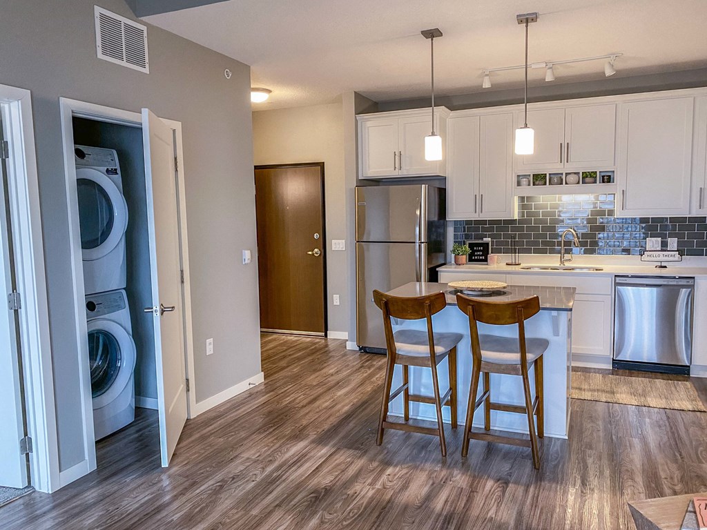 an open kitchen and dining area with white cabinets and wood floors  at Timber Ridge, Minnesota, 55025