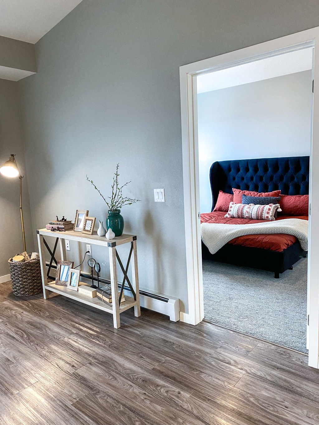 a bedroom with a bed and a white wall and wood floors  at Timber Ridge, Forest Lake, MN