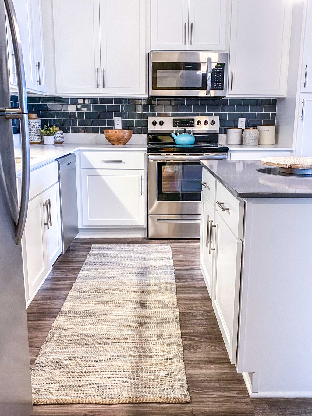 a kitchen with white cabinets and stainless steel appliances and a rug on the floor  at Timber Ridge, Minnesota, 55025