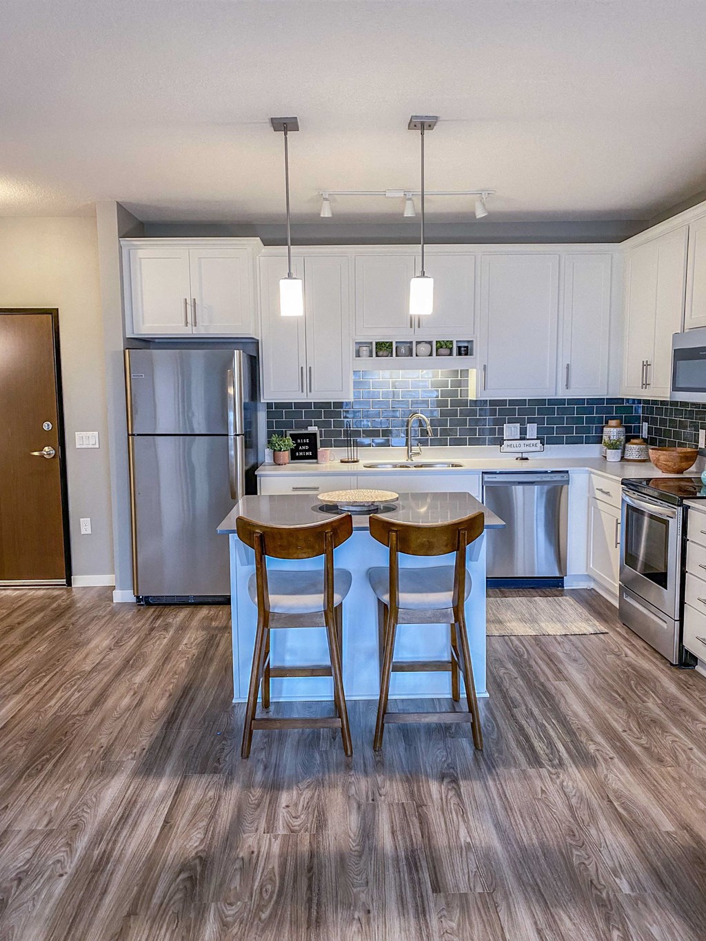 a kitchen with stainless steel appliances and a island with two stools  at Timber Ridge, Minnesota
