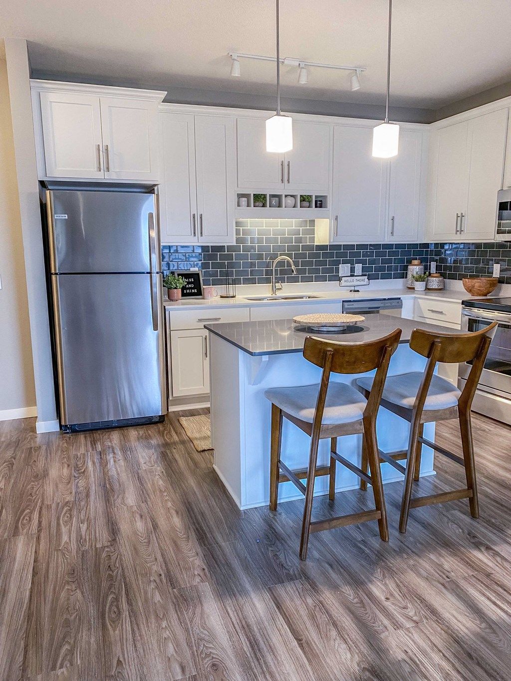 a kitchen with stainless steel appliances and two bar stools  at Timber Ridge, Minnesota