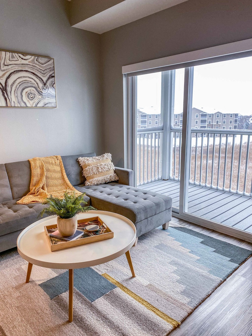 a living room with a couch and a table and a balcony  at Timber Ridge, Forest Lake