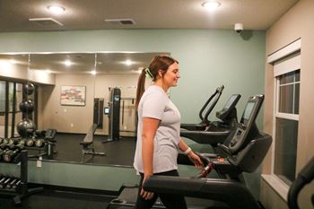 A woman is working out on a treadmill in a gym.