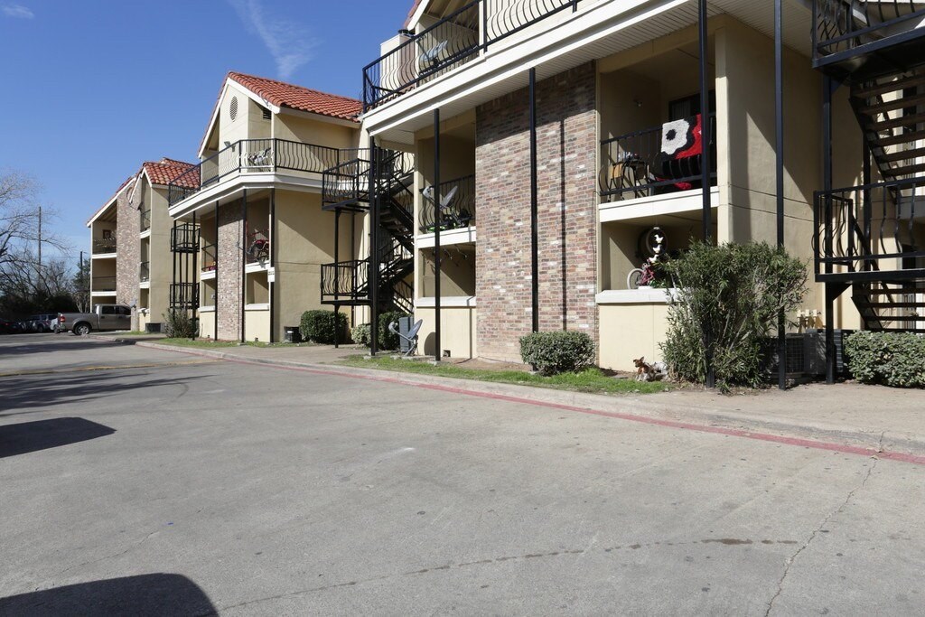Apartment complex with a parking lot in front.