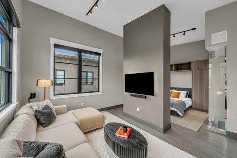 A modern living room with a large couch and a flat screen TV.