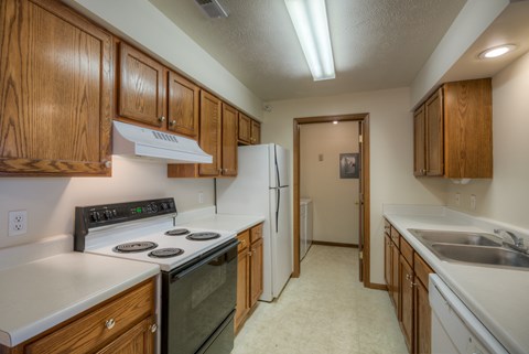 A kitchen with wooden cabinets and a black stove top.