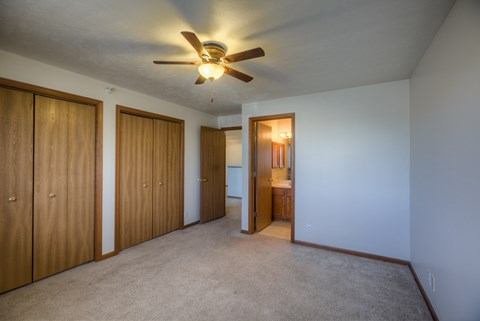 A room with a ceiling fan and a carpeted floor.