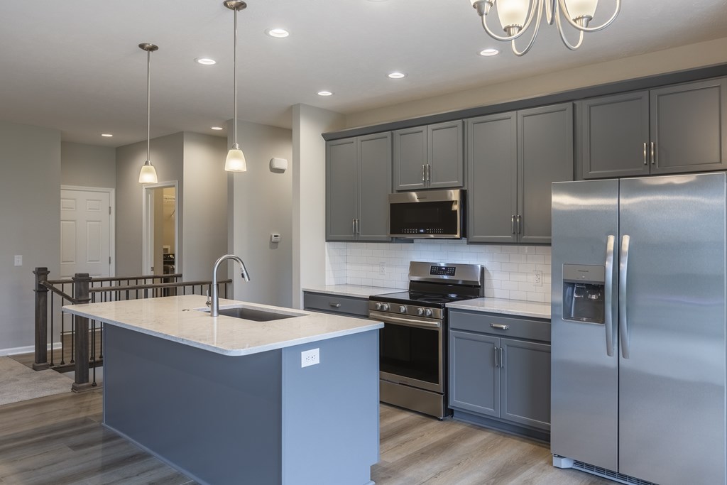 A modern kitchen with a large island and stainless steel appliances.