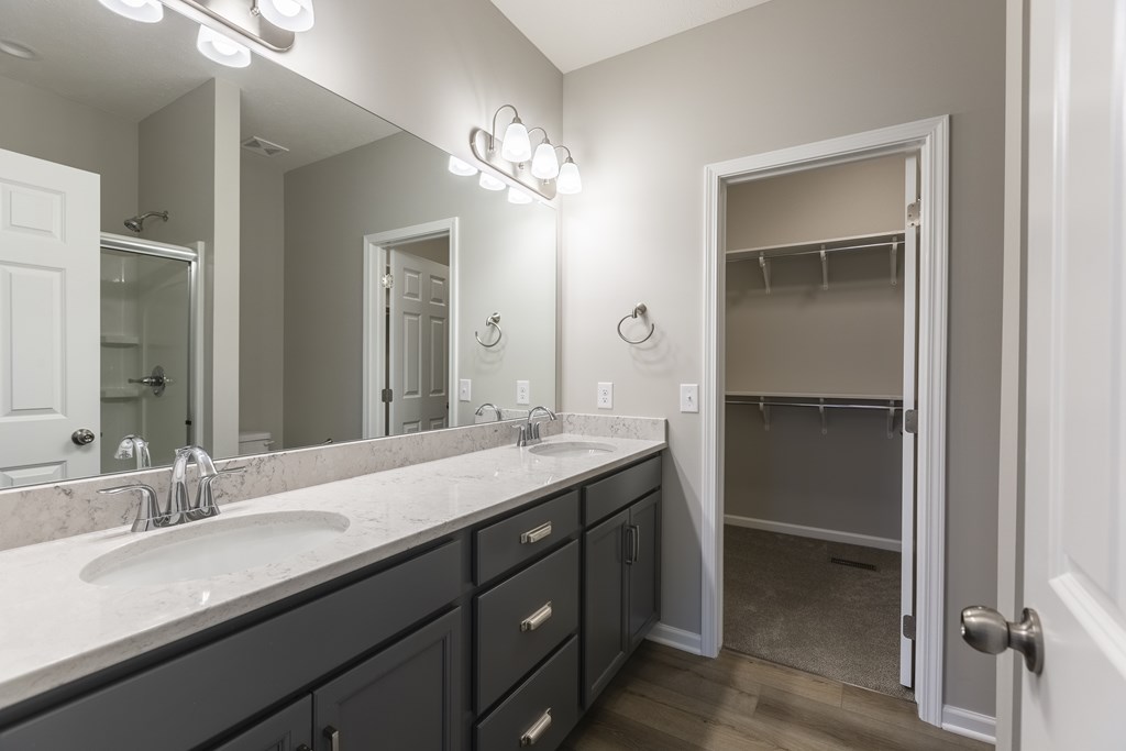 A bathroom with a double sink vanity and a large mirror.