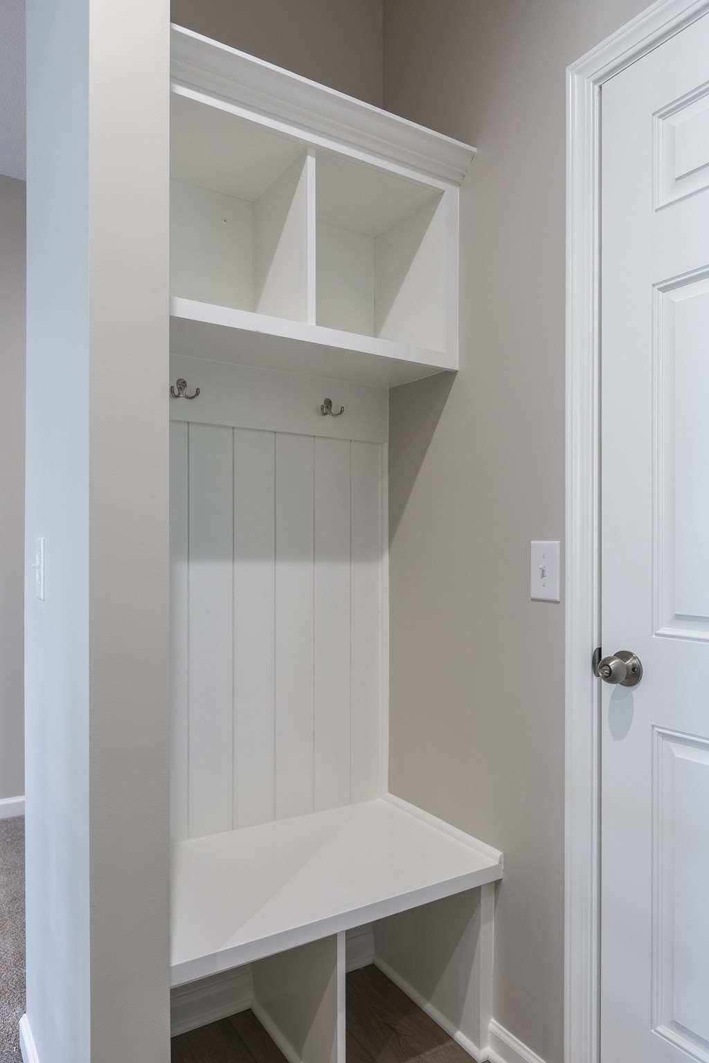 A white closet with shelves and a door.