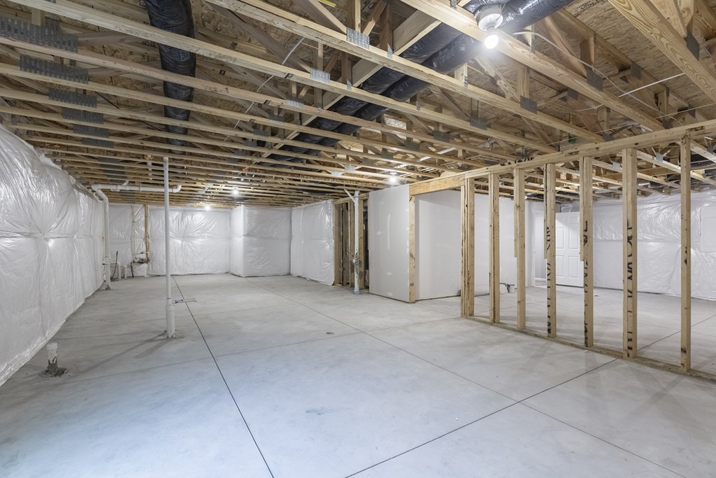 A sparsely furnished room with wooden beams on the ceiling.