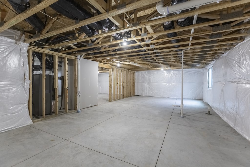 A room under construction with exposed wooden beams and insulation on the walls.