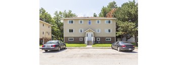 Exterior view of a two story apartment building with central entry and parking at Ashland Park II Apartments.