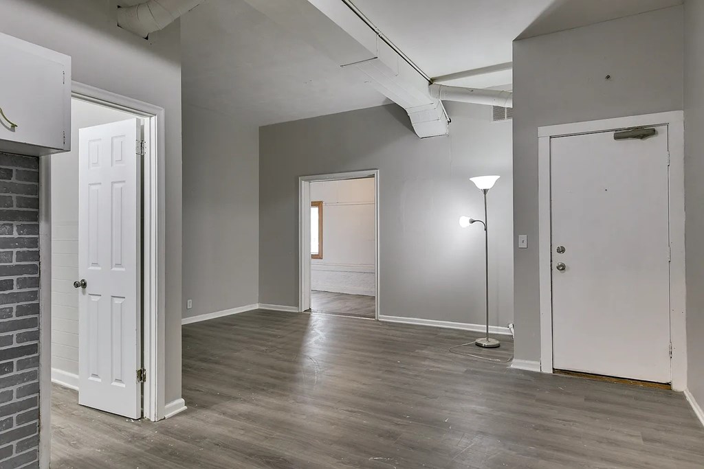 A room with a white door and a grey wall.