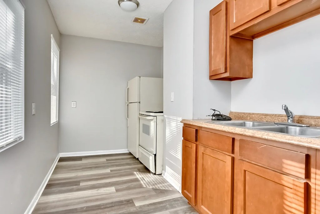 A kitchen with wooden cabinets and a white refrigerator.