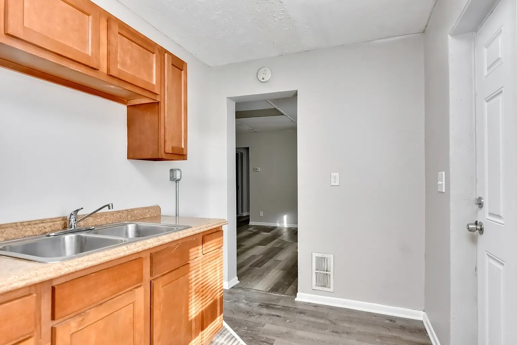 A kitchen with wooden cabinets and a white sink.