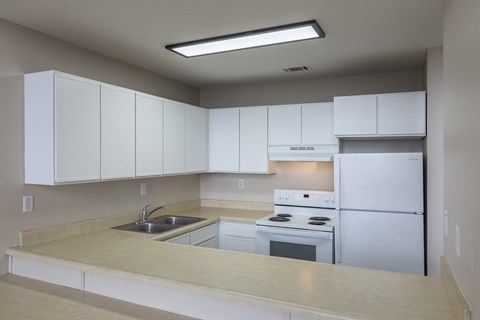A kitchen with white cabinets and appliances.